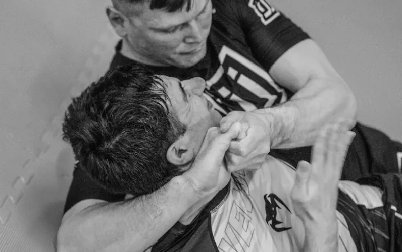 A BJJ student is sparring with another and has them in a headlock.